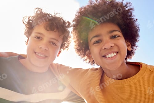 Preview: Low Angle Portrait Of Two Boys Having Fun Playing Outdoors Looking Down Into Camera With Lens Flare