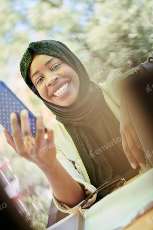 Preview: african woman using smartphone wearing traditional islamic clothes
