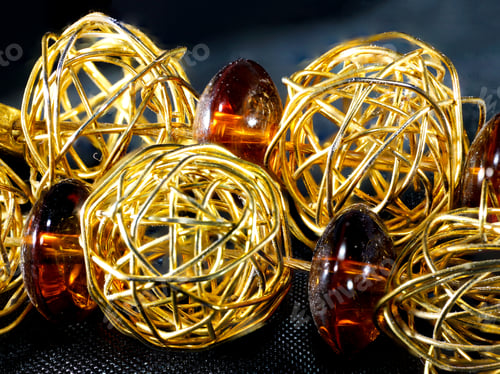 Preview: Closeup of a beautiful necklace with round golden metals and natural brown stone beads