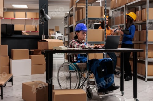 Preview: Shipment warehouse worker in wheelchair processing order on laptop