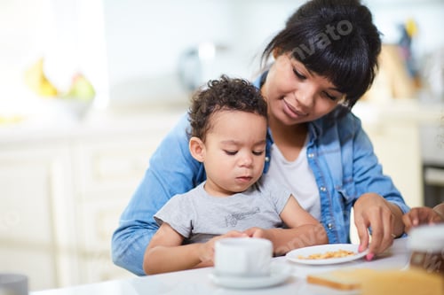 Adult and Toddler Enjoy Breakfast Together in Kitchen
