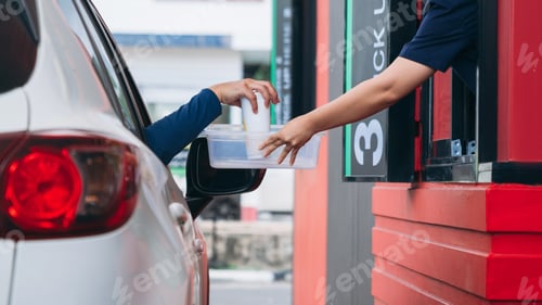 Preview: Young Man receiving coffee at drive thru counter., Drive thru and take away for protect covid19.