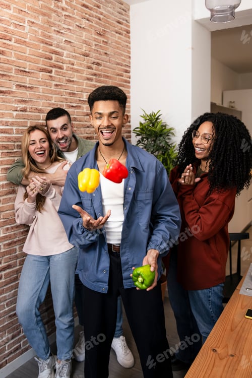 Preview: Cheerful young man juggling food while having fun with friends. Group of young adult being funny at