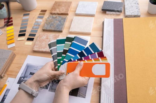 Preview: Hands of young female creative designer holding color palette over table