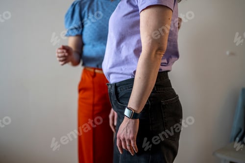 Preview: Two individuals standing side by side in casual attire.