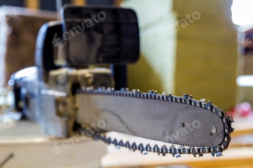 Preview: Closeup view of a chainsaw bar and cutting chain at construction site.