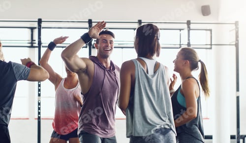 Preview: Shot of a group of young people motivating each other with a high five in a gym