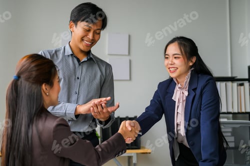 Preview: Asian businesspeople shaking hands during meeting in office