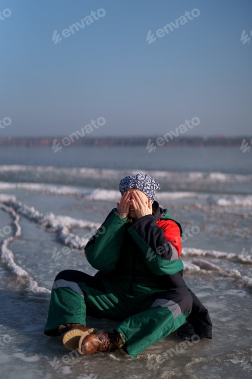 Preview: Woman enjoying winter while sitting on frozen lake. Freedom and happiness