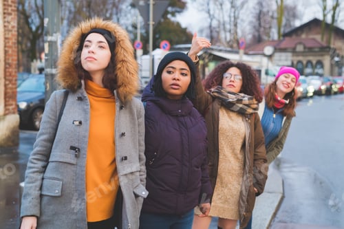 Preview: four young women multiethnic outdoor hitchhiking