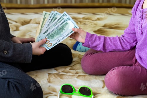 Preview: Two little children boy and girl playing with dollars money.
