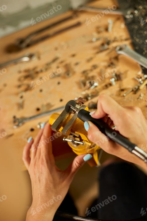 Preview: Woman using power working grinder machine, female hand grinds a metal nuts