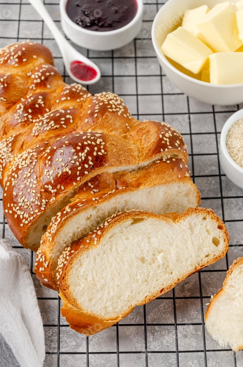 Preview: Traditional festive challah yeast bread or sweet bread with sesame, butter and jam. Jewish cuisine.