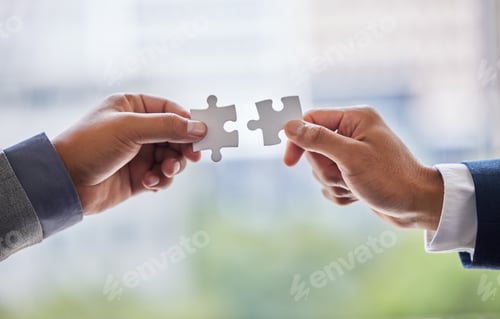 Preview: The secret lies in teamwork. Cropped shot of two businesspeople holding puzzle pieces together.