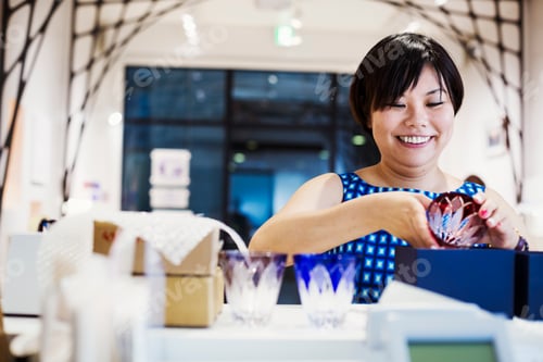 Preview: Saleswoman in a shop selling Edo Kiriko cut glass in Tokyo, Japan.