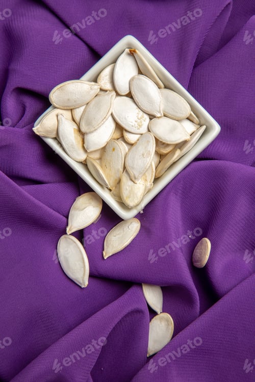 Preview: top view pumpkin seeds inside plate on purple tissue color ripe fruit food raw
