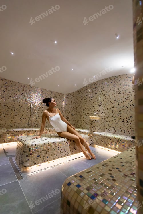 Preview: Young woman relaxing on the tepidarium bed in the spa