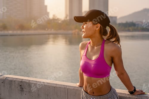 Preview: Asian women standing to see the city view after jogging a morning workout in the city.