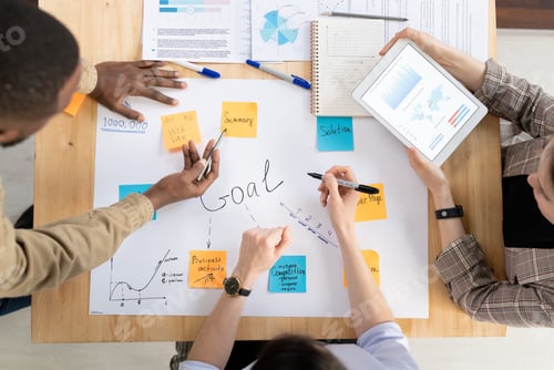 Preview: Top view of three intercultural managers or analysts discussing business goals