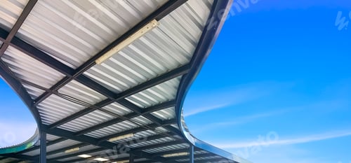 Preview: Curve steel roof with metal roof beam structure of modern covered walkway with blue sky background