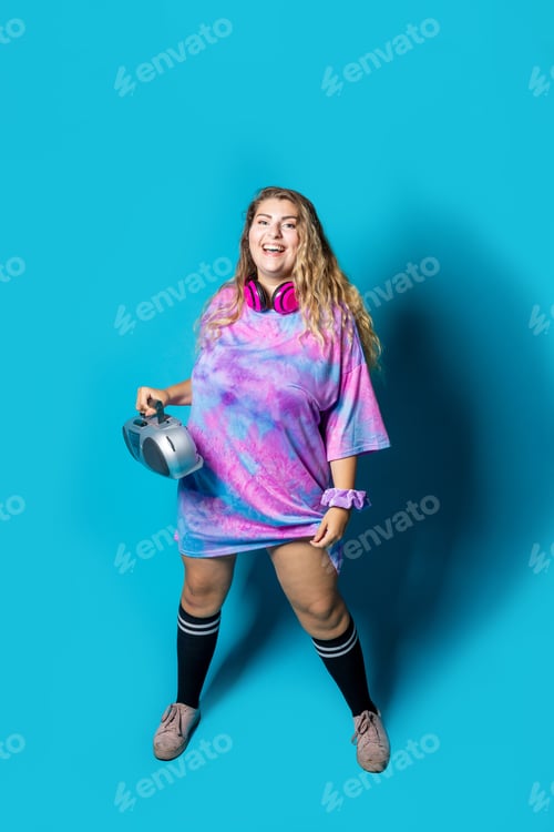 Preview: Young plus size chubby woman on blue background dancing