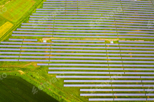 Preview: Aerial view of solar power plant on green field.