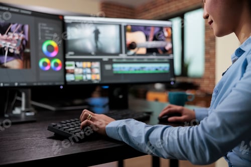 Preview: Close up shot of professional videographer sitting at desk while enhancing movie footage