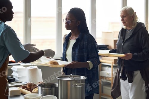 Preview: Volunteers Serving Food at Soup Kitchen During Day