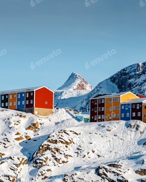 Preview: Vertical shot of colorful houses on the snowy mountains under the sunlight in Greenland