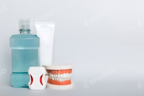 Preview: Mouthwash and other oral hygiene products on colored table top view with copy space