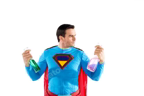 Preview: handsome superhero holding plastic spray bottles with cleaning liquid isolated on white