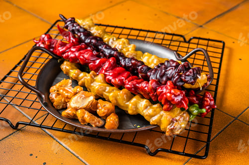 Preview: National Georgian sweets Churchkhela with walnut, hazelnuts. Orange background. Top view