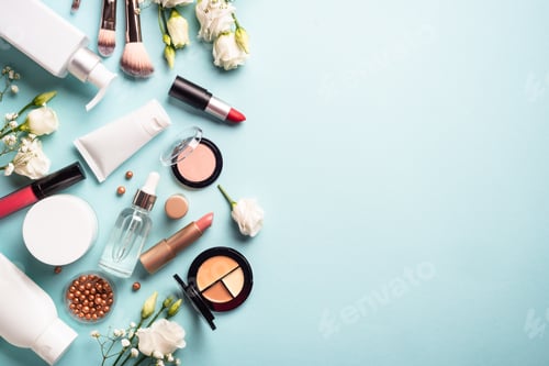 Preview: Cosmetic products on blue background with green leaves and flowers.