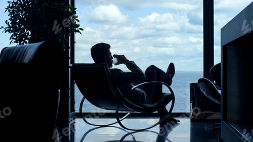 Preview: Silhouette man enjoying vacation life cognac in sea view. Businessman relaxing