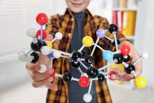 Preview: Boy with DNA structure model indoors, closeup