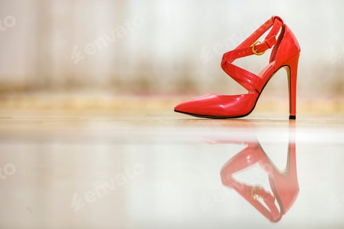 Vista previa: Fashionable high heel leather red cut-out female shoe with golden buckles isolated on light copy