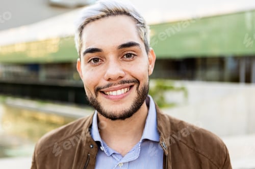 Preview: Young hispanic man smiling on camera outdoors - Portrait of happy trendy guy in the city
