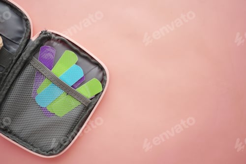 Preview: colorful adhesive bandage in a first aid bag on pink background