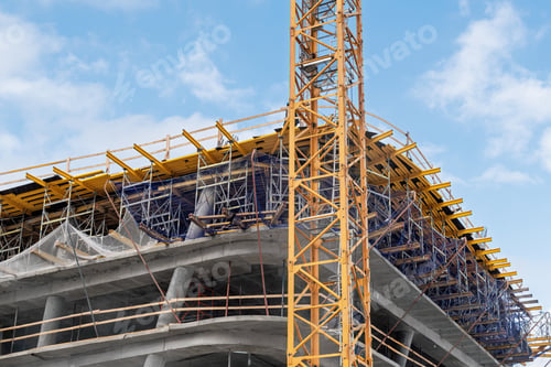 Preview: concrete building under active construction is surrounded by scaffolding and a prominent crane
