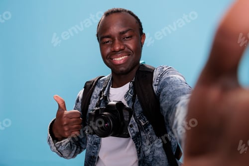 Preview: Confident photographer showing okay finger symbol while taking selfie