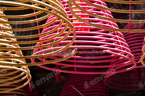 Preview: Low angle shot of colourful curly burning incenses hanging in a temple in Hong Kong, China