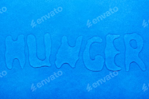Preview: The word "hunger" is written with water droplets on a blue smooth surface. Top view