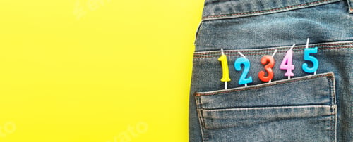 Preview: birthday candles sticking out of the back pocket of blue jeans on yellow background
