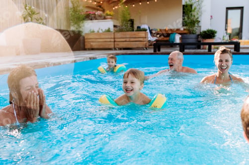 Preview: Multi generation family having fun and enjoying swimming in backyard pool during summer holiday.
