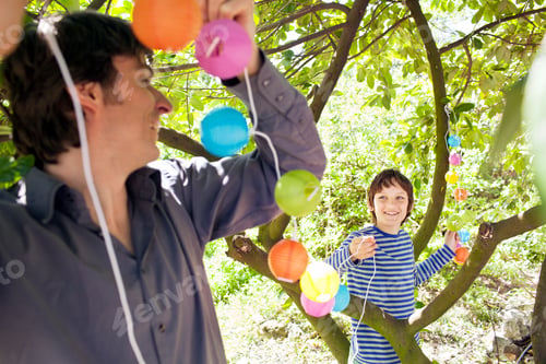 Preview: Father and son putting fairy lights in tree