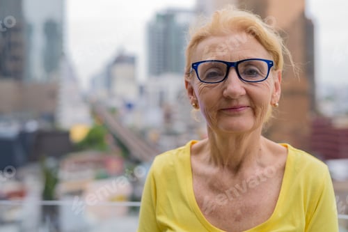 Preview: Beautiful senior woman with eyeglasses in city