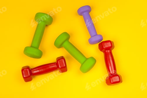 Preview: Fitness dumbbells on bright yellow background. Fitness concept