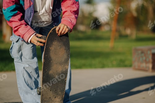 Preview: Skater holding skateboard in skatepark, getting ready to ride