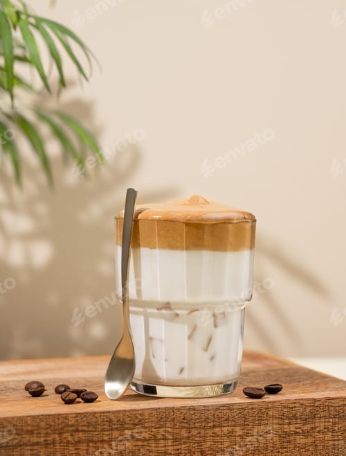 Preview: Dalgona coffee. Whipped instant coffee in a glass on a wooden stand with coffee beans