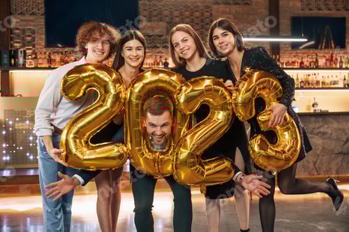 Preview: Group of people in beautiful elegant clothes are celebrating New Year indoors together